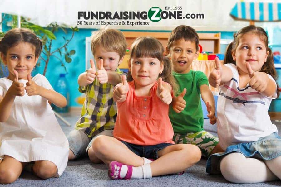 Group Of Kids Sitting On The Floor Giving Us A Thumbs Up For Our Best Daycare Fundraising