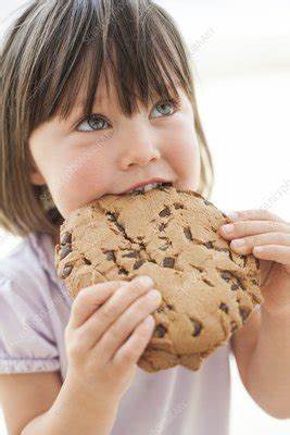Child eating a big chocolate chip cookie