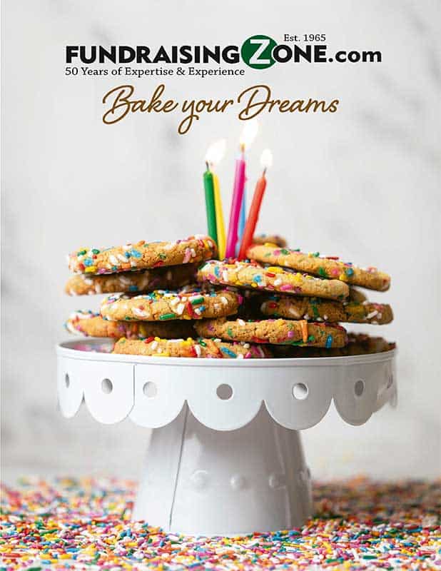 Sprinkle cookies with lit candles atop a white stand, sprinkles around; "Bake your Dreams" promotes FundraisingZone.com profits. Click to learn more about this cookie dough program.