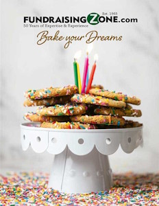 A stack of sprinkle cookies with candles on a cake stand, surrounded by sprinkles and "Bake your Dreams"—ideal for fundraisers.