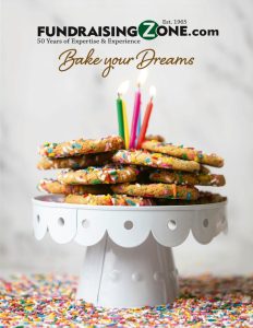 Sprinkle-topped cookies with birthday candles on a white stand. “FundraisingZone.com. Bake your Dreams.” Ideal for school fundraisers!.