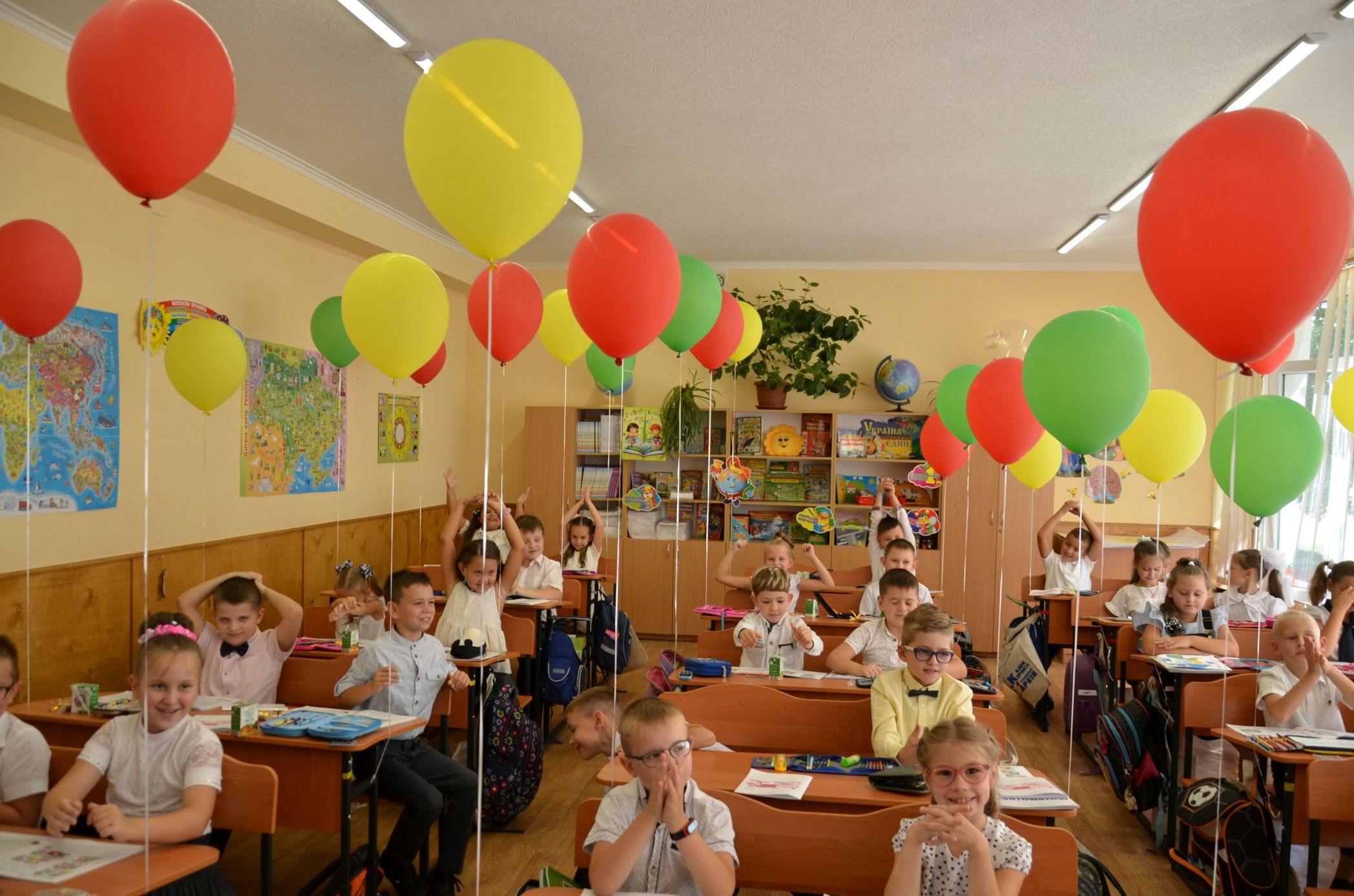 Elementary students celebrating in a classroom with balloons